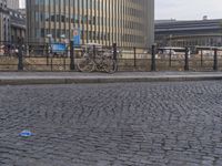 the sidewalk has a little blue can laying on it's side, and a blue plastic ball in front of it