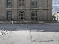 some old buildings are in the middle of an empty courtyard with stone floor and railings