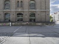 some old buildings are in the middle of an empty courtyard with stone floor and railings