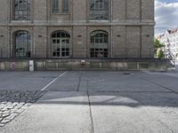 some old buildings are in the middle of an empty courtyard with stone floor and railings