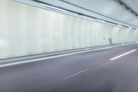 a blurry photo of a highway in an empty tunnel, with light coming through the opening