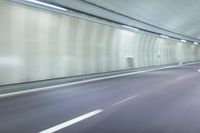 a blurry photo of a highway in an empty tunnel, with light coming through the opening