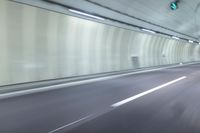 a blurry photo of a highway in an empty tunnel, with light coming through the opening
