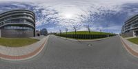 a fisheye lens shows a car turning on a street in front of apartment buildings