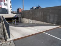 a parking area next to a building with no windows and concrete walls on it is closed