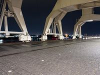 the car is parked in the side walk of the bridge at night near other vehicles