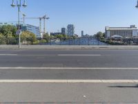 the city is behind a fence on a sunny day at the edge of a river