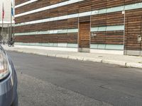 a car parked in front of an empty building with wooden slats on the side