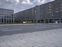 empty street in front of office buildings on cloudy day with no people sitting or walking