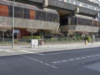 a very large building with some windows is standing on the side of the road at an intersection