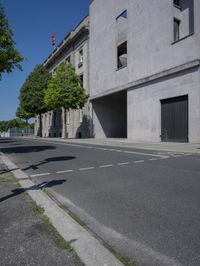 a skateboarder is doing tricks on a empty street corner in the daytime sun