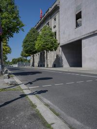 a skateboarder is doing tricks on a empty street corner in the daytime sun