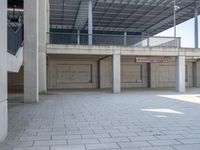 an empty parking garage with large ceilings next to a wall of windows and concrete floors