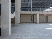 an empty parking garage with large ceilings next to a wall of windows and concrete floors