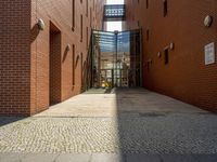 a brick walkway in front of a building on an angle that is a sidewalk and a building on the side is an entrance