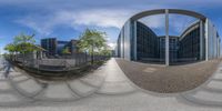 a photo of a very large building with some trees in it's yard and a view through a round mirror