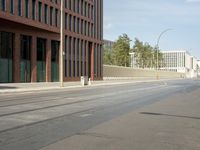 the building with three floors has many windows in it and cars on the street by the street