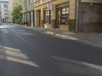 a person riding down the road near a parked car, with no traffic visible in the way