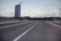 the street is empty with cars and lights on the side of it at night time