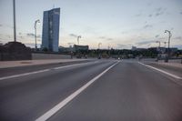 the street is empty with cars and lights on the side of it at night time