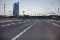 the street is empty with cars and lights on the side of it at night time