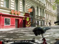 a restaurant in the middle of a narrow city street with graffiti on the wall and the sidewalk outside the building