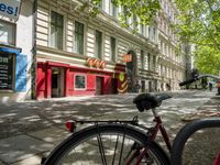 a restaurant in the middle of a narrow city street with graffiti on the wall and the sidewalk outside the building