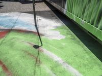 a sidewalk that has a spray painting on it next to an orange and green pole