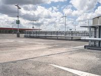 an empty parking lot with several cars parked outside of the building and a street light above them