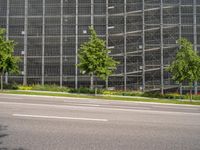 the street is empty and some trees near it, along with a building behind it