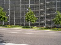 the street is empty and some trees near it, along with a building behind it