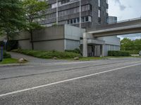 a long narrow highway going under an elevated street bridge with cars passing underneath it and a car driving up the hill