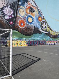 a painting of an elephant is shown in a parking lot outside a fenced area