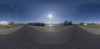 a circular shot of three cars parked at the side of a street near an oil field with a sky background