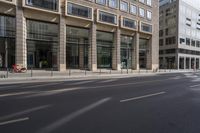 a city street with cars passing by some office buildings with lots of glass and metal windows