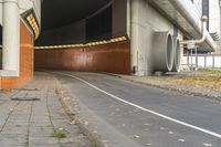 an underpass on the side of a road leading to the city street and tunnel