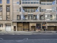 a street corner with several windows and a building in the background that appears to be an old factory