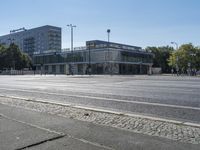 an empty city street with several buildings and cars passing by them with one car in the foreground