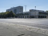 an empty city street with several buildings and cars passing by them with one car in the foreground