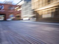 a blurry photo shows cars driving on a city street as it goes through the buildings