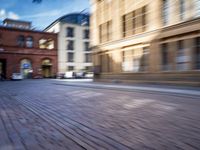 a blurry photo shows cars driving on a city street as it goes through the buildings