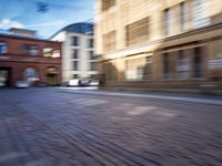 a blurry photo shows cars driving on a city street as it goes through the buildings