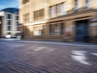 a blurry photo shows cars driving on a city street as it goes through the buildings