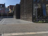 a person walking on a city sidewalk next to buildings and trees in the foreground