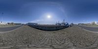 a fish eye view with a large ship in the background and a smaller boat to the right