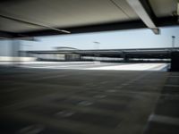 motion blurs shot of empty parking lots under the roof of an overpass building