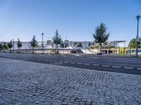 empty street with no people or cars near a building and a park structure in the distance