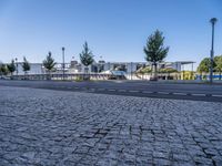 empty street with no people or cars near a building and a park structure in the distance