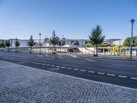 empty street with no people or cars near a building and a park structure in the distance