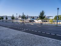 empty street with no people or cars near a building and a park structure in the distance